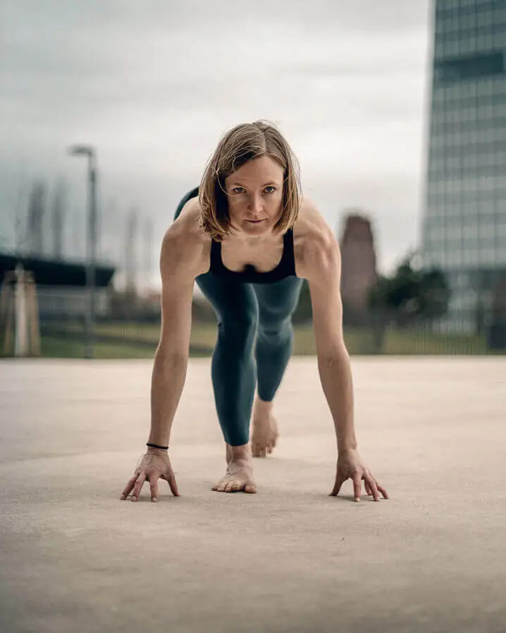 Woman doing yoga in Lisbon in Spritner Postition looking at you