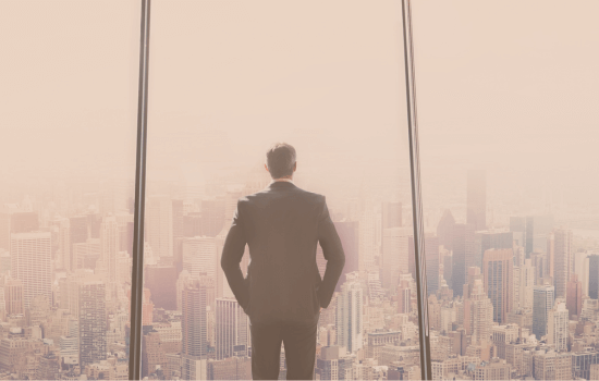 Businessman in a suit standing in front of a large office window overlooking a modern city skyline, symbolizing leadership, ambition, and corporate success.